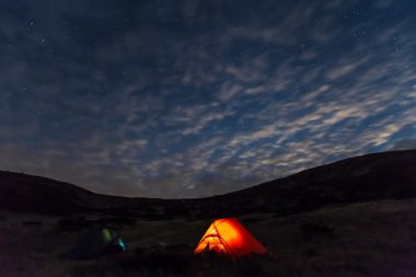 Işıklı çadır ile gece dağ manzarası