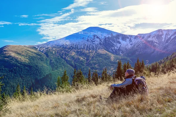 Kvinna sitter på gula gräsbevuxen meadow njuter av varm solljus — Stockfoto