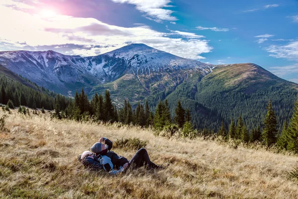 Kvinna sitter på gula gräsbevuxen meadow njuter av varm solljus — Stockfoto