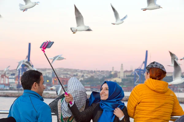 Улыбающиеся арабские дамы, делающие автопортрет с морскими чайками — стоковое фото