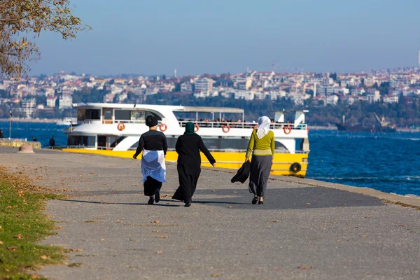 Μουσουλμανική κυρίες περπατώντας στον παραλιακό δρόμο του θάλασσα ακτή προς βάρκα — Φωτογραφία Αρχείου