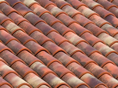 Clay (terracotta) tiles on the roof of a country house clipart