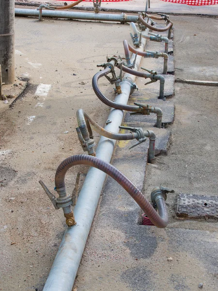 Временные металлические трубы пересекают дорогу — стоковое фото