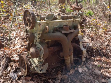 Doğada terk edilmiş bir arabanın motoru, doğal çevrenin bozulma ve kirlenmesinin bir sembolü.