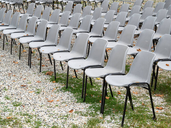 group of empty grey plastic chair arranged in rows waiting for the people after coronavirus covid 19 pandemic
