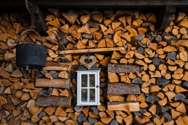 Деревянная глыба, украшенная старым фонарем, каулдроном и деревянным сердцем — стоковое фото