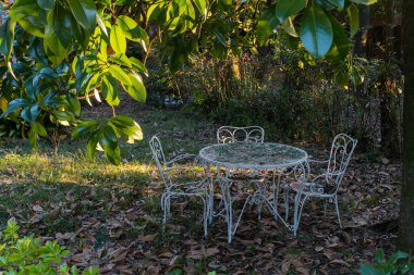 white  wrought iron table and two chairs abandoned  under a magn