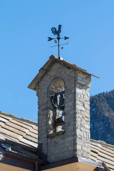 Small belltower of an old mountain church   weather cock on the — Zdjęcie stockowe