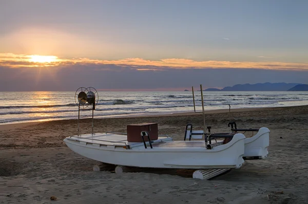 Невеликий скляний рибальський човен на пляжі на заході сонця — стокове фото