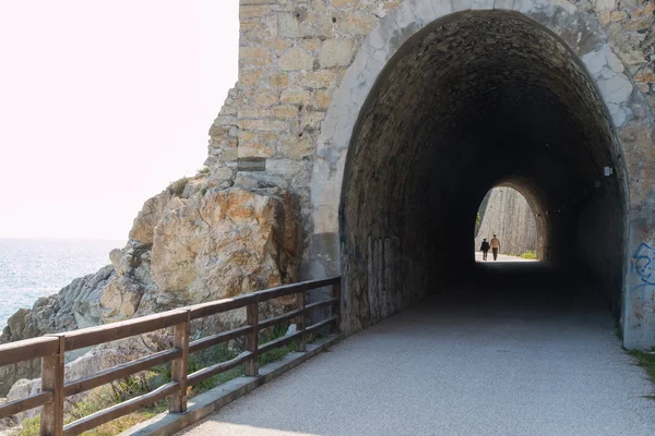 Dos personas un hombre y una mujer caminan de la mano fuera de un túnel —  Fotos de Stock