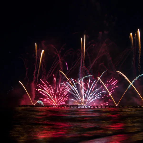 Fireworks reflecting in the water from Forte dei Marmi's Pier — Stock Photo, Image