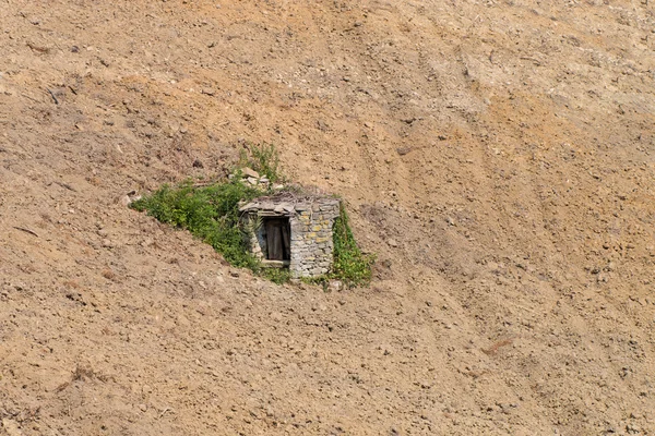 Alter Brunnen aus Stein in einem gepflügten Feld piemont italien — Stockfoto