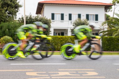 Team of cyclists blurred for speed in a chrono bicycle race clipart