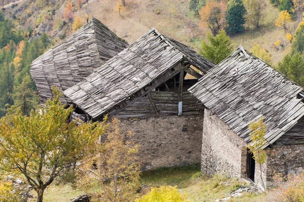 Old damaged wooden roofs of abandoned chalets in Italian Alps — Stock Photo, Image