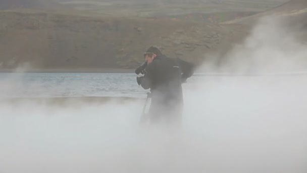 Videógrafo filmando aguas termales a través del vapor — Vídeo de stock