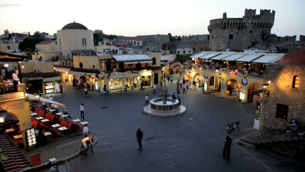 Люди, наслаждающиеся вечером на площади Гиппократов, старый город Родес, Греция — стоковое видео