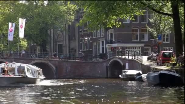 Amsterdam med sin traditionella kanalsystem och många broar används av nederländsk tävlingscyklist. — Stockvideo