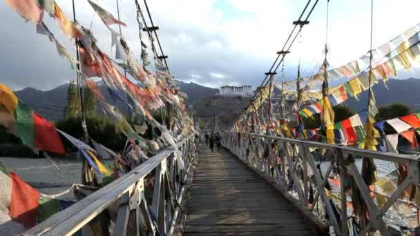 I bambini delle scuole attraversano il ponte coperto di bandiere di preghiera — Video Stock