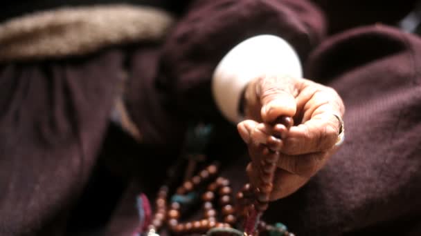 Hand of elderly woman using prayer beads — Stock Video