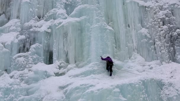 Is klättrare på frusna vattenfall — Stockvideo