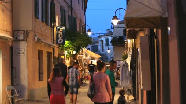 Personas que se relajan por la noche en la calle italiana — Vídeo de stock