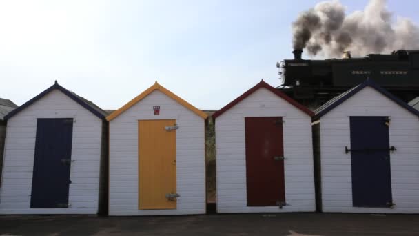 Tren de vapor pasando Beach Huts, Reino Unido — Vídeo de stock