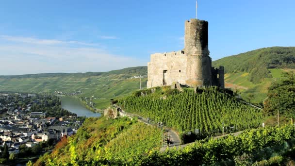 Tourist climbing a hillside path near the ruins of Landshut castle — Stock Video