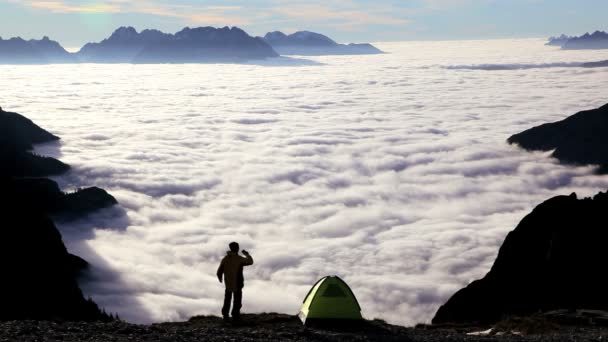 Escursionista con binocolo sopra le nuvole — Video Stock