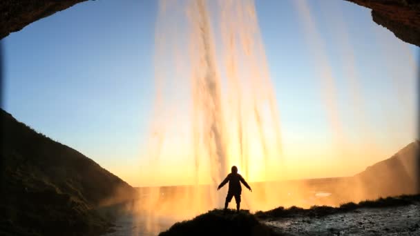 İzlanda Skogafoss şelale günbatımı erkek doğa kaya yüzüne — Stok video