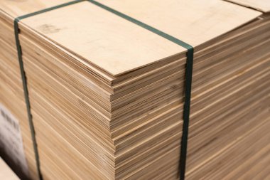 OSB kağıtları bir nalbura istiflenmiş. İnşaat malzemesi ahşaptan.