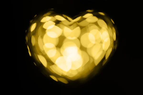 Golden bokeh cuore su sfondo nero — Foto Stock