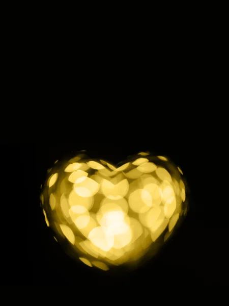 Golden bokeh cuore su sfondo nero — Foto Stock