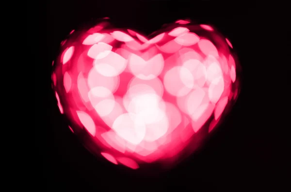 Corazón bokeh rosa sobre fondo negro — Foto de Stock