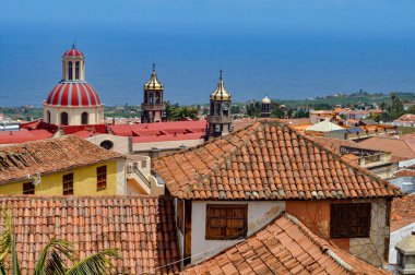 Mavi gökyüzüne ulaşmak için kilisenin mahzenleriyle harmanlanmış kiremitli çatılar.