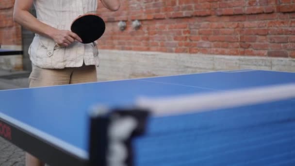 Tennisbord. eldre kvinne som spiller tennis på gatebordet på gata – stockvideo