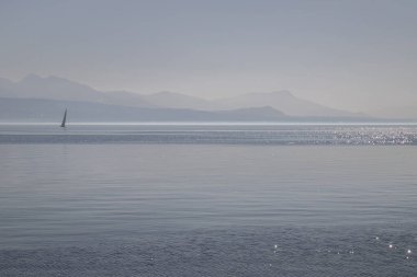 Sisli bir tekne, sisli Geneva Gölü ve İsviçre, Lozan 'dan görülen Alpler.