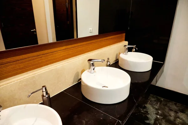 Beautiful interior of modern toilet with sinks and mirror in hotel or office building