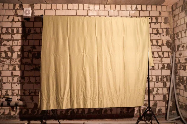 Rag background in room with brick walls. Background in the photo studio for photography and photo shoot. Fabric for posing