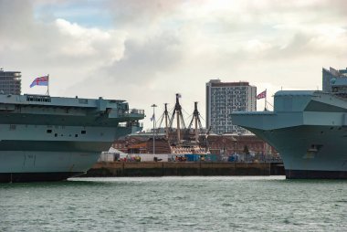 Kraliyet Donanma uçak gemileri HMS Queen Elizabeth ve HMS Prince of Wales arasında Portsmouth, İngiltere 'de görülen tarihi HMS Zaferi.