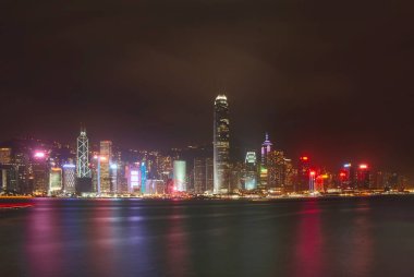 Hong Kong 'daki Victoria Limanı' ndaki rıhtım boyunca aydınlık gökdelenler.