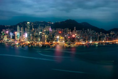 Hong Kong 'daki Victoria Limanı' ndaki rıhtım boyunca aydınlık gökdelenler.