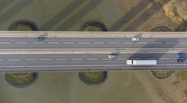 Suffolk, İngiltere 'de büyük bir nehri geçen bir köprüdeki trafiğe bakan bir insansız hava aracının görüntüsü.