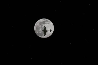 The silhouette of a Supermarine Spitfire Mk IIa against a full moon clipart