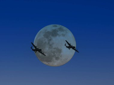Kalan son iki Avro Lancaster ağır bombardıman uçağı dolunay tarafından siluetlendi.