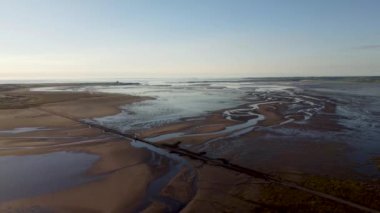 Lindisfarne, Northumberland, İngiltere 'ye giden kutsal adanın 4k insansız hava aracı görüntüleri.