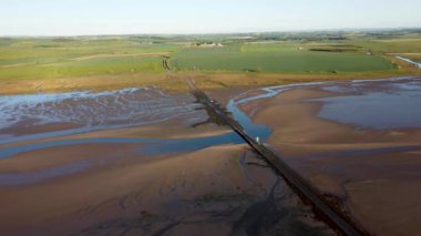 Lindisfarne, Northumberland, İngiltere 'ye giden kutsal adanın 4k insansız hava aracı görüntüleri.