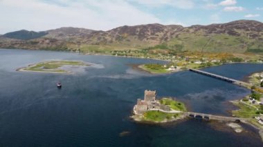 İngiltere, İskoçya 'daki Loch Duich' e bakan antik Eilean Donan Kalesi 'nin 4k drone görüntüleri.