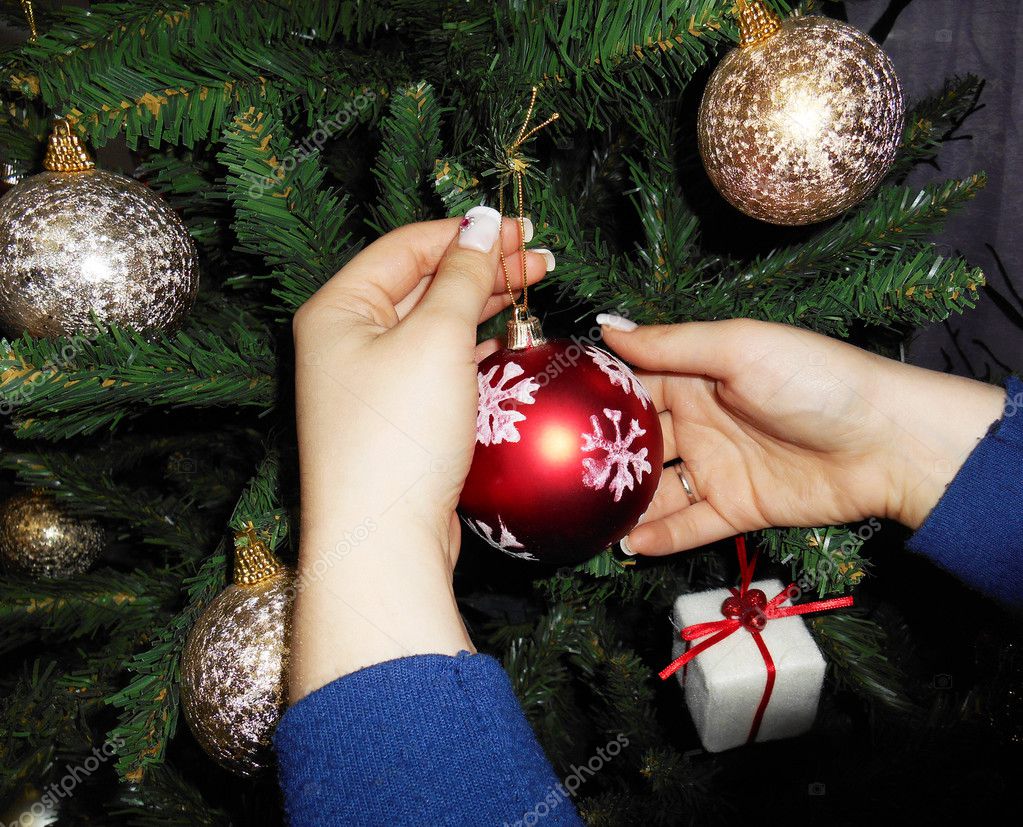 Young woman hanging christmas ornaments on a christmas tree — Stock ...