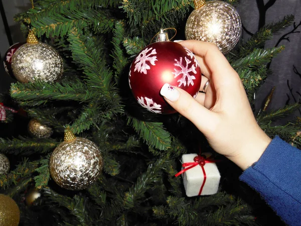 Mujer joven colgando adornos de Navidad en un árbol de Navidad — Foto de Stock