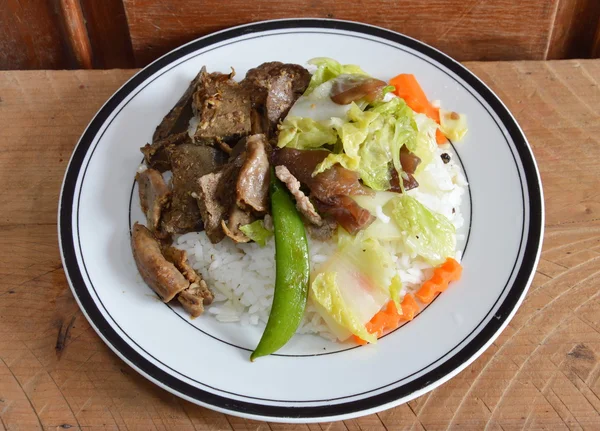 Isi perut babi goreng dengan bawang putih dan sayuran campur aduk goreng di atas nasi — Stok Foto
